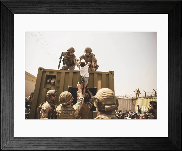 Framed Print : US Marines lift a child over a barrier at Kabul Airport, Afghanistan, Aug. 20, 2021