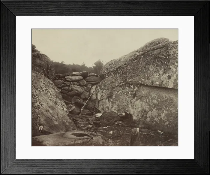 Framed Print : A dead Confederate soldier lies in the Devil's Den, against a wall of stones, with his rifle, on the Gettysburg battlefield, c. July 4-6, 1863