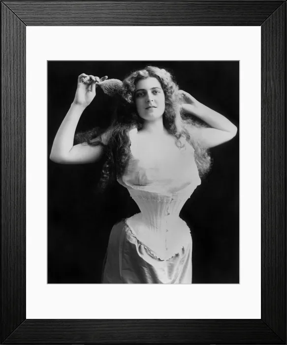 Framed Print : Woman wearing a flat fronted corset, shaping the fashionable pigeon breast Gilded Age silhouette. Photo is dated 1899 (BSLOC_2018_3_97)