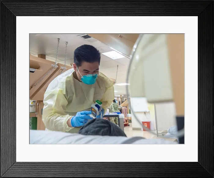 Framed Print : Navy Seaman Luis Librando prepares to take a patient's temperature aboard the USNS Mercy in Los Angeles, April 7, 2020