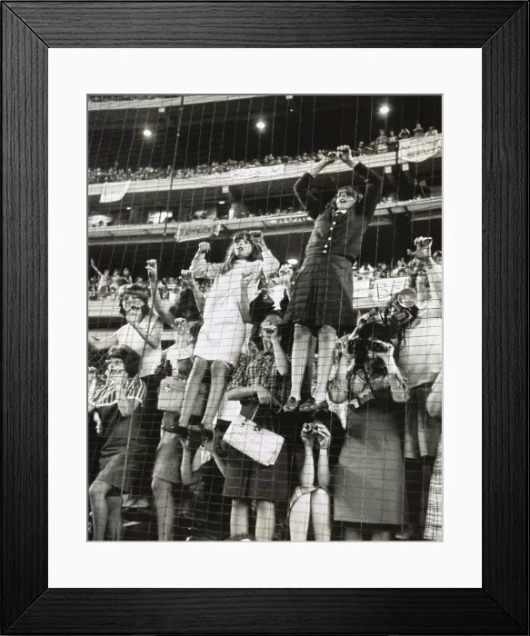 Framed Print : Teenage girls climb a wire fence to get a better view of the British singing group, the Beatles, at Shea Stadium, August 15, 1965