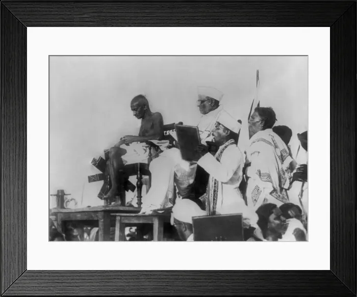 Framed Print : Mohandas Gandhi at the Triplicane Beach meeting in Madras, March 7, 1925. His spinning wheel is beside him as he spins cotton yarn (BSLOC_2020_2_170)