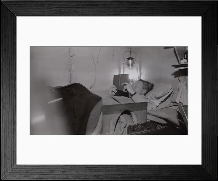 Framed Print : Admiral Richard Byrd reading by lantern light in his basecamp bunk at Little America, Antarctica. 1928-1930 (BSLOC_2018_2_38)