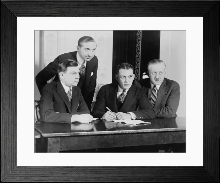 Framed Print : Football half-back, Harold E. Grange, signing a movie contract, at the Hotel Astor, ca. 1924. Depicted, L-R: W.E. Schallenberger, Pres. Of Arrow Pictures; Harry G