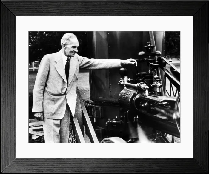 Framed Print : Henry Ford marking his 78th birthday by toying with an early steam threshing machine on the Michigan farm where he used to work as a youth. ca. 1941