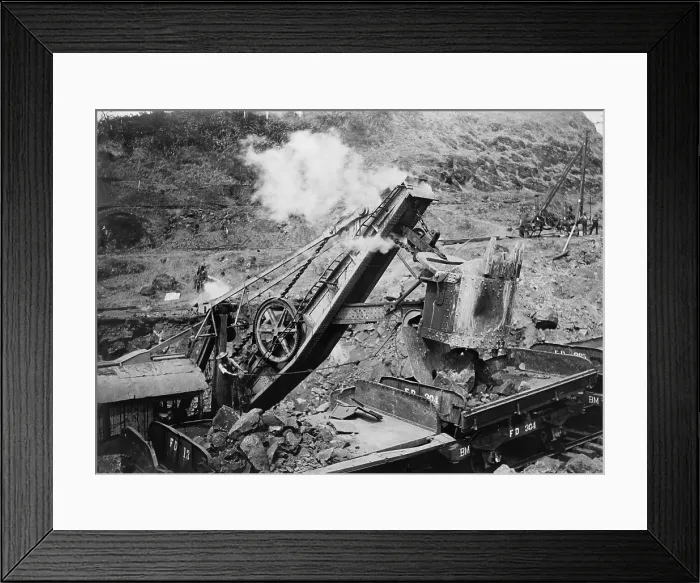 Framed Print : Business end of 95 ton steam shovel loading boulders onto train cars at the Panama Canal, c. 1907-13