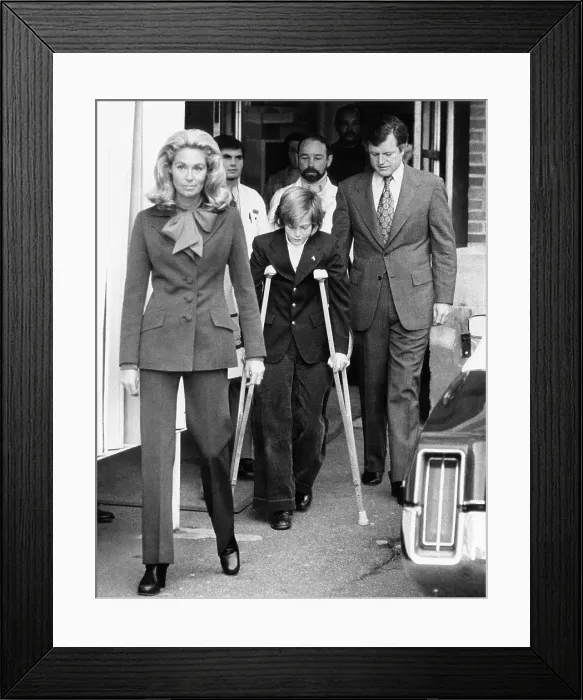 Framed Print : Senator Edward Kennedy, right, and his wife, Joan Kennedy, with their son, Edward Kennedy, Jr. as he leaves Georgetown University Hospital after having a leg amputated