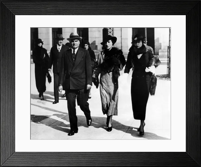 Framed Print : Louis Froelich, attorney for the Vanderbilt family (front left), and Gloria Morgan Vanderbilt (right), leaving the custody hearing of Gloria Laura Vanderbilt, circa July 25, 1934