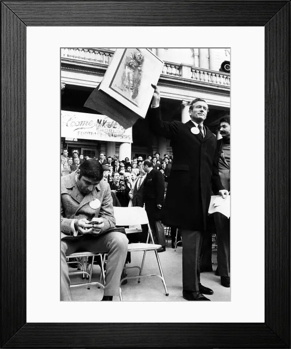 Framed Print : Joe Namath, examines a bronze medallion presented to him by New York City Mayor John Lindsay. Mayor Lindsay holds a picture of Namath in action