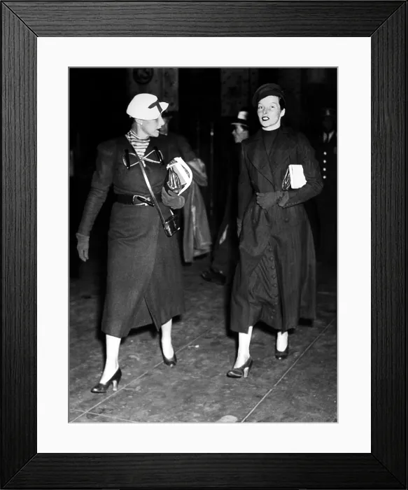 Framed Print : Katharine Hepburn (r) and her secretary Laura Harding (l), arrive at Penn Station, after she obtained a divorce from Ludlow Smith in Mexico. New York, New York, May 3, 1934