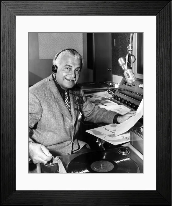 Framed Print : Boston Pops Orchestra leader, Arthur Fiedler, spins a record while doing a disc-jockey stint for radio station KEAR in San Fransicsco. ca. 1955