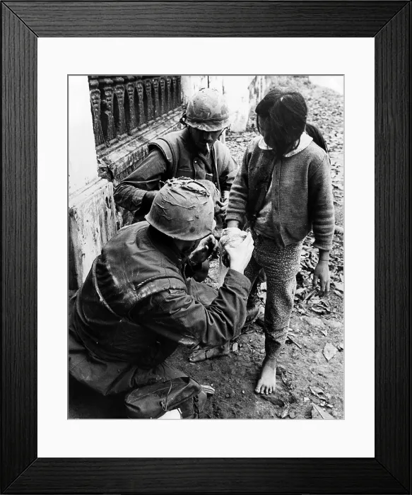 Framed Print : EV1949 - Two U.S. Marines apply bandages to the hand of a Vietnamese girl who was wounded during street fighting in Hue, South Vietnam, February 11, 1968