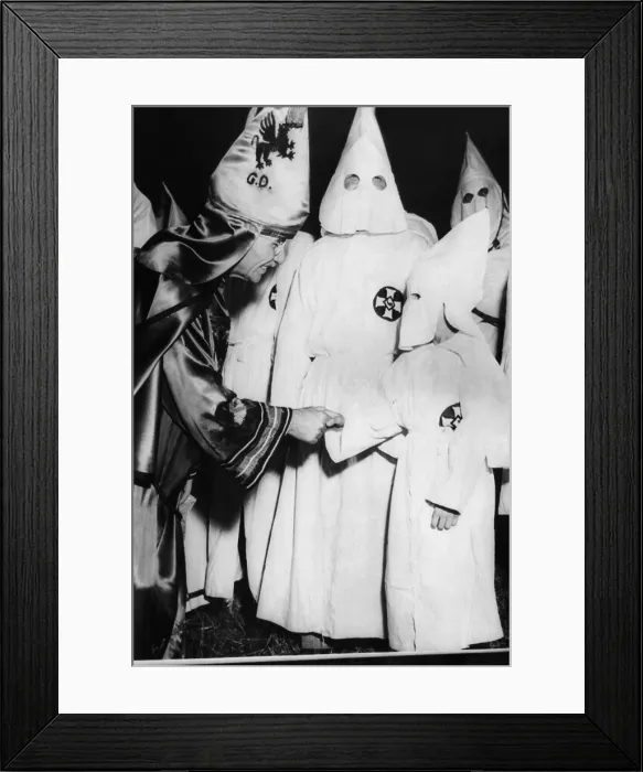 Framed Print : Dr. Samuel Green (left), Grand Dragon of the Ku Klux Klan, greets a small boy dressed in Klansman's robes