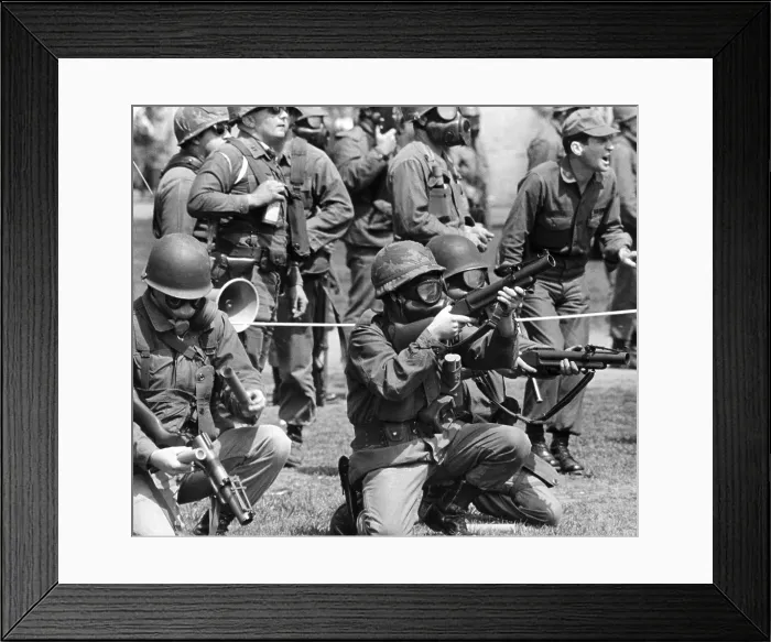 Framed Print : Masked national guardsmen fire barrage of tear gas into crowd of demonstrators on campus of Kent State University. When the gas dissipated, 4 students lay dead and 9 others injured. May 4, 1970