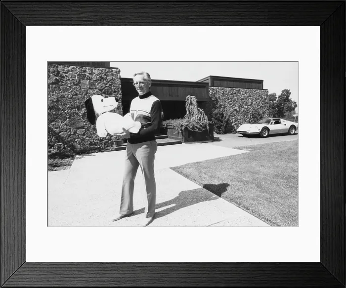 Framed Print : Charles M. Schulz, (1922-2000), American cartoonist and creator of the comic strip Peanuts, holding a Snoopy doll, Santa Rosa, California, 1975