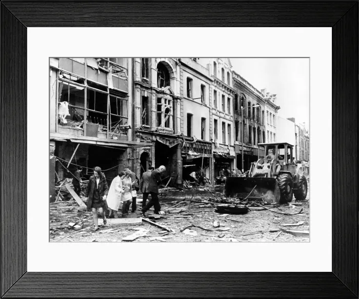 Framed Print : A bulldozer clears away debris in a devestated shopping area following the explosion of a 250-pound bomb, in Londonderry, Northern Ireland. July 21, 1972
