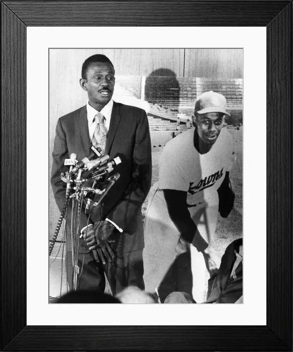 Framed Print : Pitcher Leroy Satchel Paige (1906-1982), standing beside a picture of himself as he is receiving recognition for outstanding achievements in the Negro Baseball League