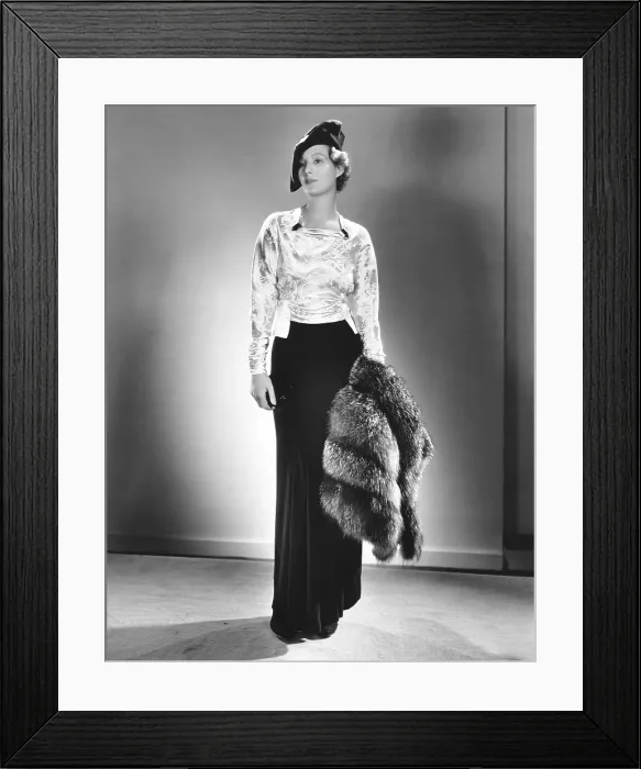 Framed Print : Binnie Barnes, modeling a cocktail ensamble of green brocade and velvet, with emerald dress clips and silver fox cape, 1935