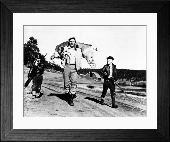 Framed Print : Robert Mitchum (center), and his sons, Chris Mitchum (left), and Jim Mitchum (right), after hunting a six-point buck, circa 1952. Courtesy: CSU Archives / Everett Collection