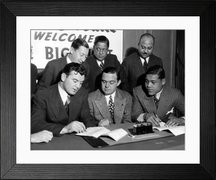 Framed Print : James Braddock and Joe Louis sign contract for upcoming fight. Looking on are the Boxing Commission Chairman and the fighters trainers. Chicago, IL, February 19, 1937
