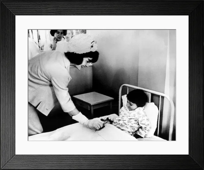 Framed Print : Jacqueline Kennedy (left), presents a patient at the children's hospital with a flower in Bogota, Colombia. December 17, 1961. Courtesy: CSU Archives / Everett Collection