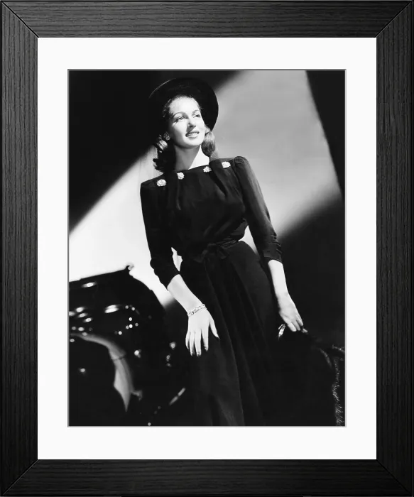 Framed Print : Lana Turner in black ensemble featuring a short fur jacket, pearl clips at the shoulders and a velvet bonnet with a misty veil, ca. 1940