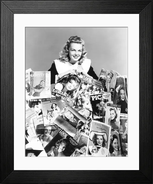 Framed Print : Elyse Knox posing amid all of the magazines which feature her picture on the cover, 1943