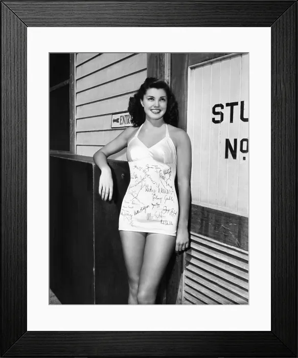 Framed Print : MGM starlet Esther Williams, who's had her fellow players autograph her swimsuit, 1942