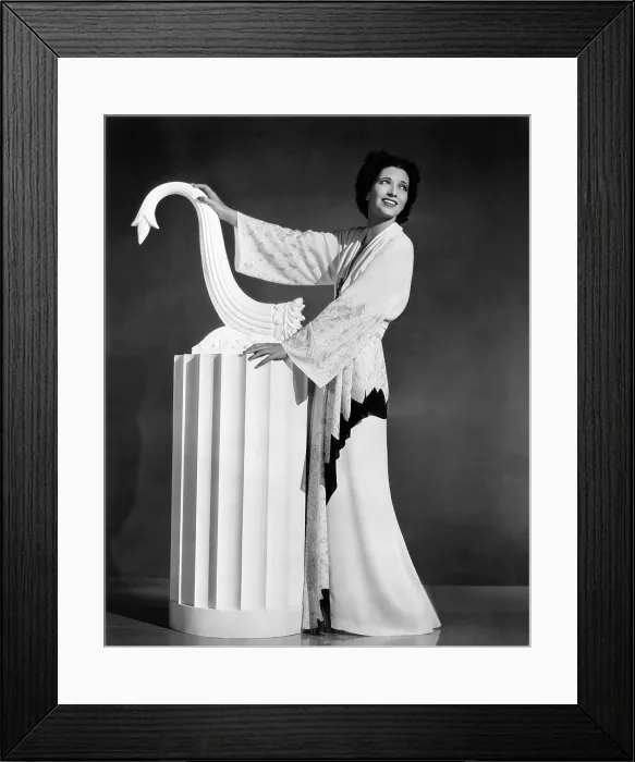 Framed Print : Kay Francis modeling white-crepe lounging robe with crimson trim, 1937 Framed Print : Kay Francis modeling white-crepe lounging robe with crimson trim, 1937