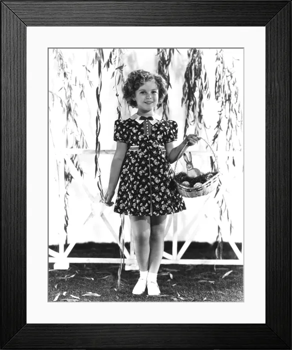 Framed Print : Shirley Temple, modeling a red, white and blue print dress with a blue velvet bow at the neck, ca. 1936 Framed Print : Shirley Temple, modeling a red, white and blue print dress with a blue velvet bow at the neck, ca. 1936