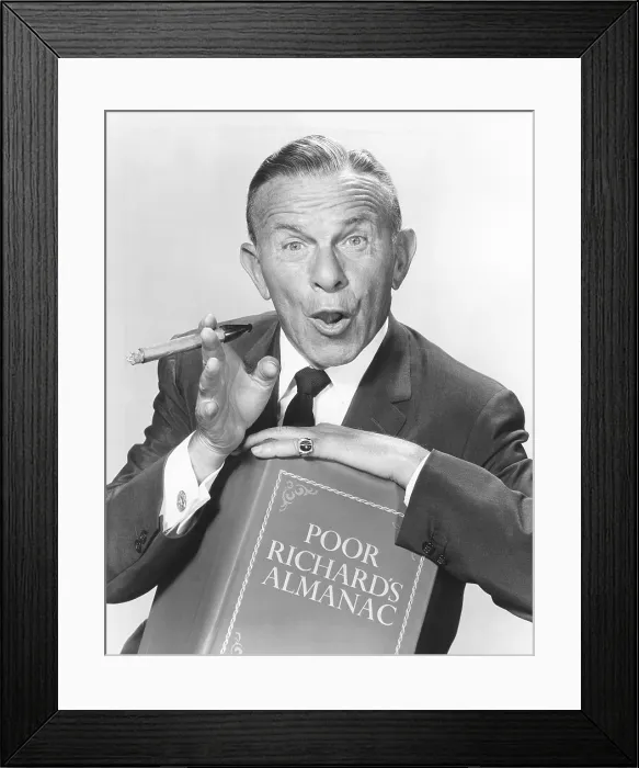 Framed Print : George Burns, holding a copy of Poor Richard's Almanac, circa 1950s