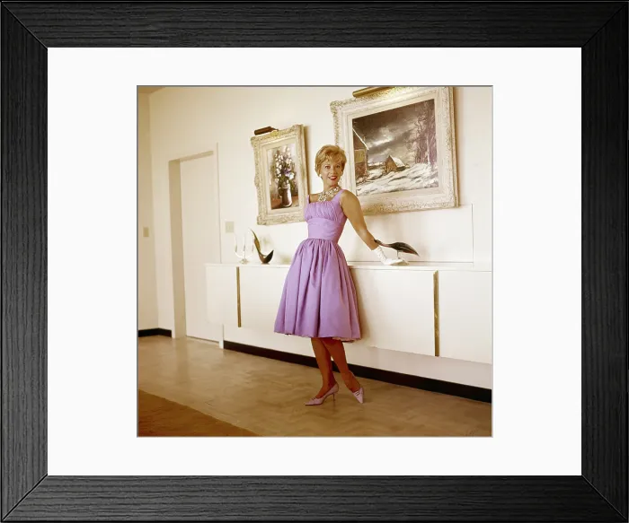 Framed Print : Dinah Shore at home, (paintings she created are on the wall behind her), circa 1960s