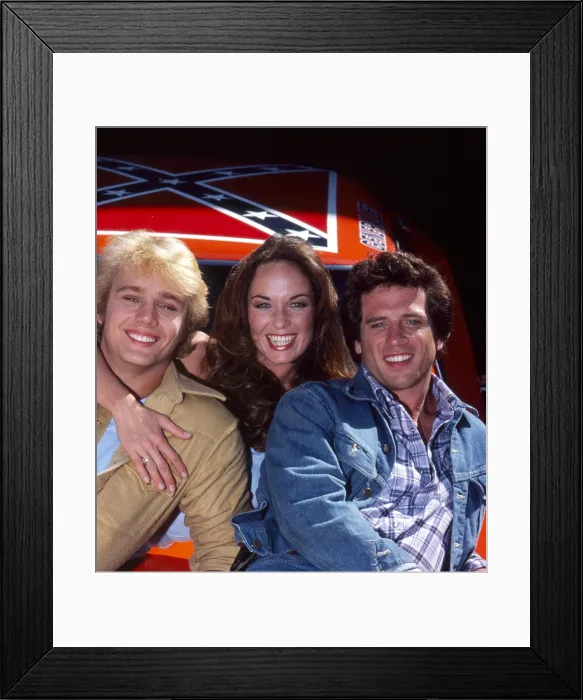 Framed Print : THE DUKES OF HAZZARD, from left: John Schneider, Catherine Bach, Tom Wopat, 1979-1985 Framed Print : THE DUKES OF HAZZARD, from left: John Schneider, Catherine Bach, Tom Wopat, 1979-1985