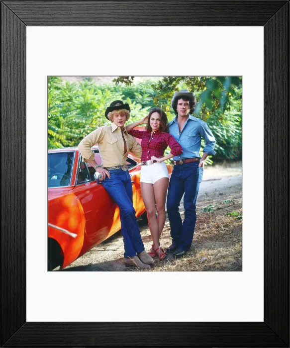 Framed Print : DUKES OF HAZZARD, from left: John Schneider, Catherine Bach, Tom Wopat, 1979-1985 Framed Print : DUKES OF HAZZARD, from left: John Schneider, Catherine Bach, Tom Wopat, 1979-1985