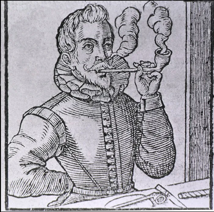 Framed Print : 16th century Dutchman smoking a long-stemmed pipe, with another pipe and roll of tobacco on the table