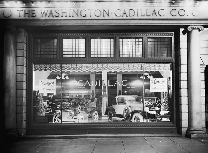 Framed Print : 1927 Cadillac LaSalle (right) shares the showroom window with a vintage model. The Washington, D.C. dealership window compares the speed of Prof