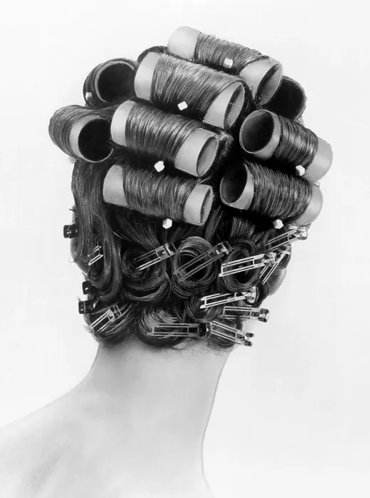 Framed Print : 1960s bouffant hair styles were created with big rollers on top of the head and pin curls to create a soft flip up at the neck. Back view. June 25, 1962