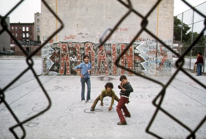 Framed Print : 1970s America. Three young boys pose in front of a graffitied wall in a park in Brooklyn, New York City, ca. 1973