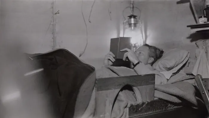 Framed Print : Admiral Richard Byrd reading by lantern light in his basecamp bunk at Little America, Antarctica. 1928-1930 (BSLOC_2018_2_38)