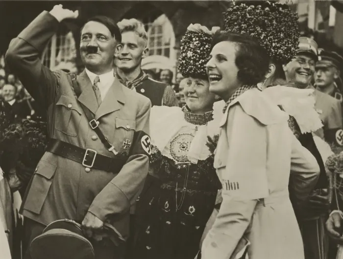Framed Print : Adolf Hitler and filmmaker, Leni Riefenstahl, with joyous smiles. They are in a group with woman wearing traditional German costumes and uniformed Nazis