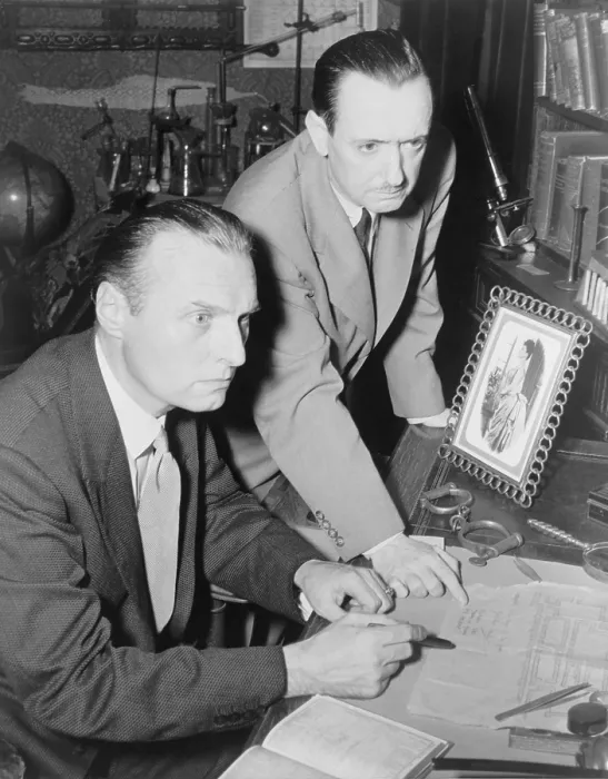 Framed Print : Adrian Conan Doyle (1910-1977), son of Arthur Conan Doyle (1868-1952), and mystery writer John Dickson Carr (1906-1977) at desk, plotting a new Sherlock Holmes story. 1952