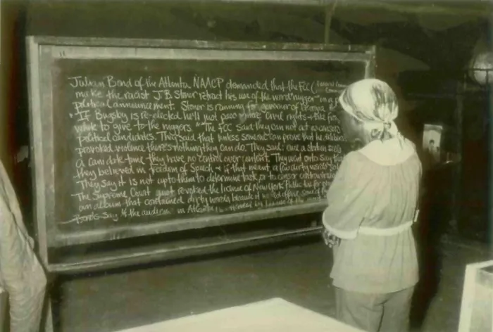 Framed Print : An adult education student reading about Julian Bond. People's Temple Agricultural Project. Jonestown, Guyana. Nov. 1978