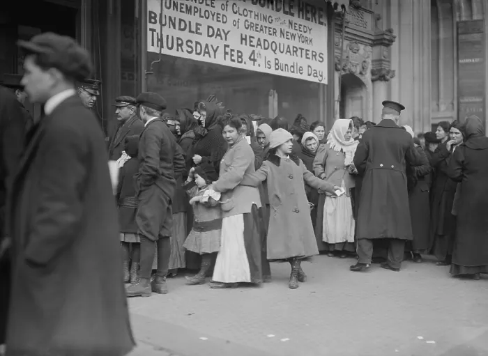 Framed Print : Adults and children gather for clothing distribution in NYC, Feb. 1915. Sign reads, Bundle of Clothing for the Needy Unemployed of Greater New York. Thursday Feb