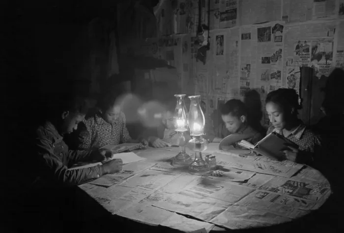 Framed Print : African American children reading by kerosene lantern light at a diner table, Depew, Oklahoma, Feb. 1940. The table and walls are covered with newspapers. Photo by Russell Lee