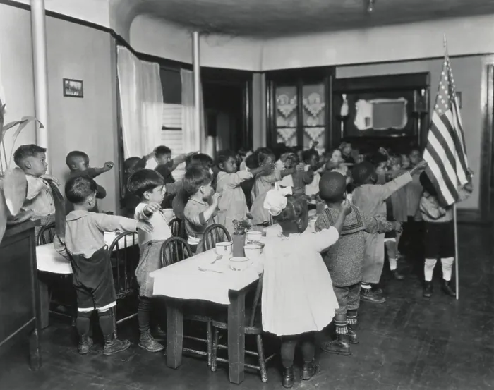 Framed Print : African American children salute the flag in classroom, c. 1910. The primary school children make the old straight arm salute
