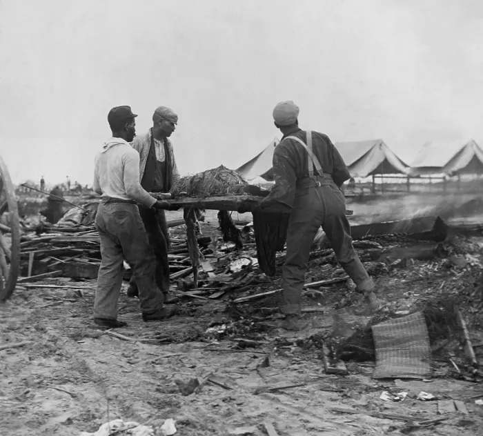 Framed Print : African American men carrying a body on stretcher to a fire (at right) to be cremated. Initial burials at sea caused bodies to be washed back to the Texas coast. Sept