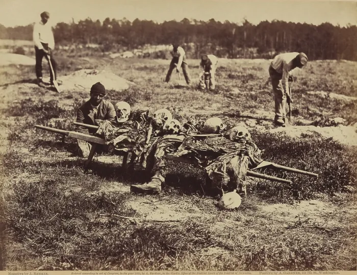 Framed Print : An African American soldier of a burial party on the battle-field of Cold Harbor seated next to a stretcher containing remains of Union soldiers who perished in the battles of