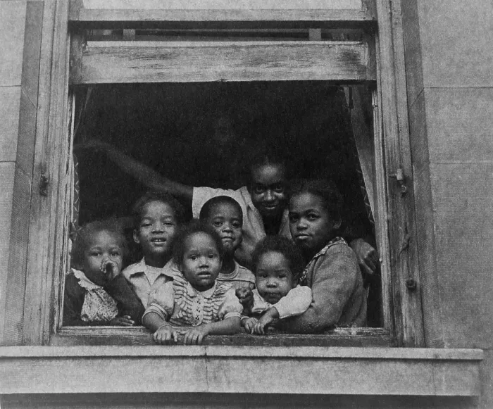 Framed Print : African American woman and six children at window of a city apartment building ca. 1950