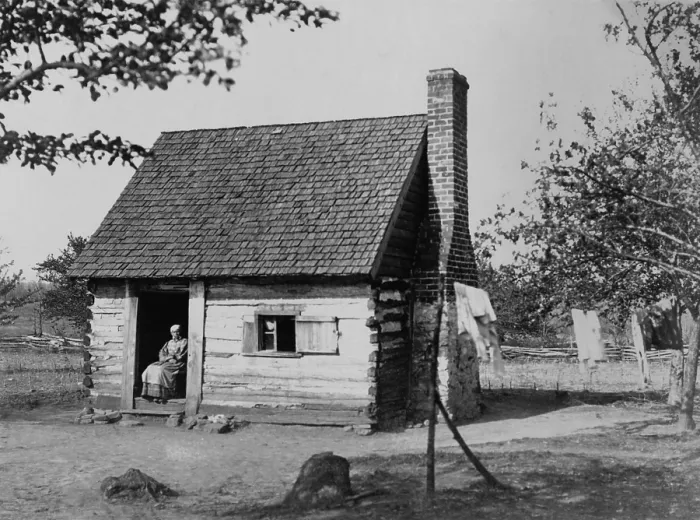 Framed Print : African American woman seated in log cabin doorway, which possibly once housed slaves, ca. 1890 (BSLOC_2020_2_96) Framed Print : African American woman seated in log cabin doorway, which possibly once housed slaves, ca. 1890 (BSLOC_2020_2_96)