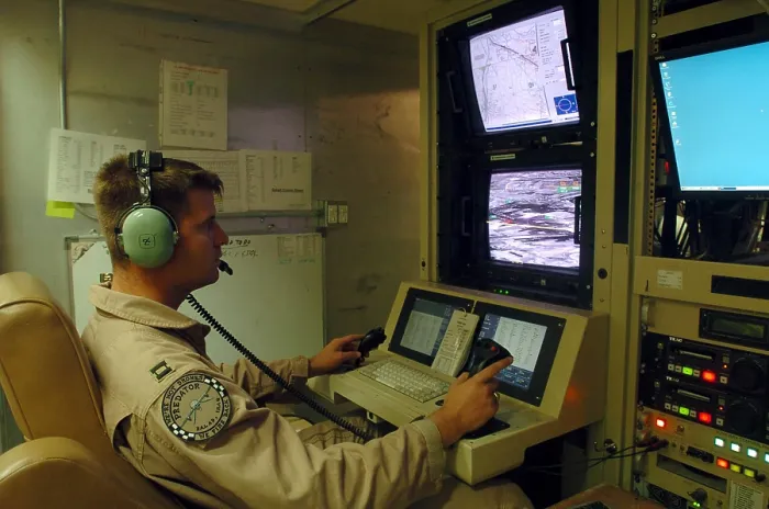 Framed Print : An Air Force officer maneuvers an unmanned Predator reconnaissance airplane over Iraq by remote control at Balad Air Base Iraq. July 2 2004. (BSLOC_2011_12_299)